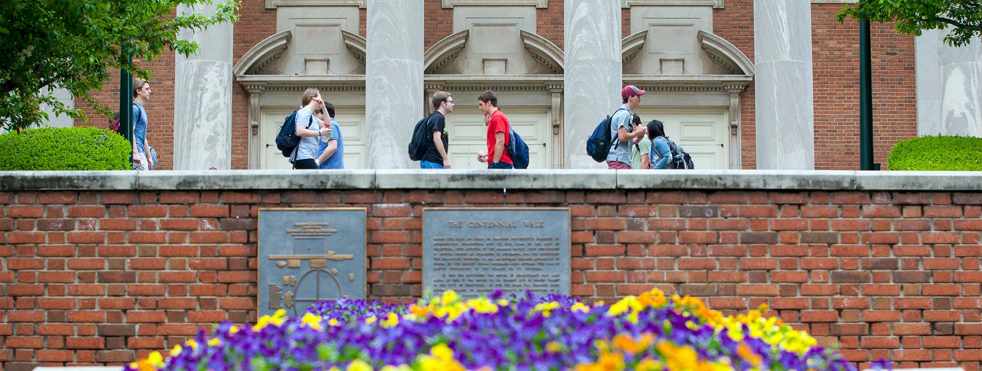 Students walking in front of the library header